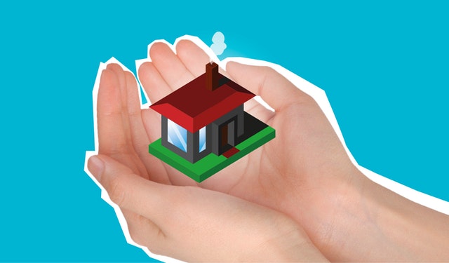 person holding a little model home